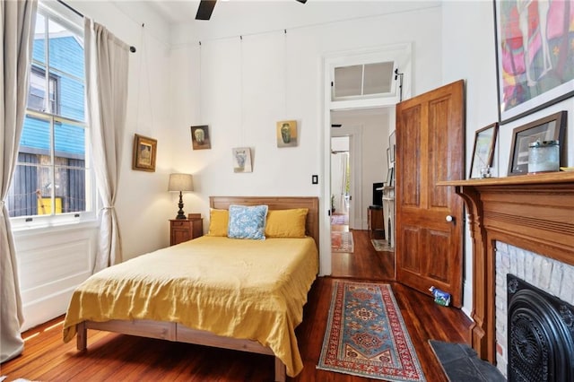 2329 Dauphine St, New Orleans, LA 70117 - bedroom with dark wood-type flooring and a tiled fireplace
