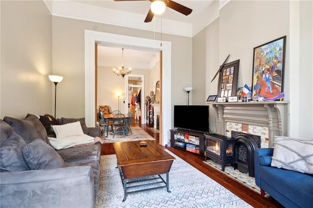 2329 Dauphine St, New Orleans, LA 70117 - living room with wood finished floors, crown molding, ceiling fan, a chandelier, and a wood stove