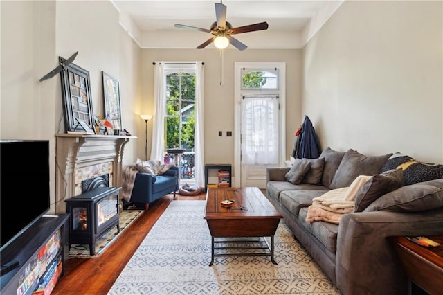 2329 Dauphine St, New Orleans, LA 70117 - living area featuring wood finished floors, ceiling fan, and a wood stove