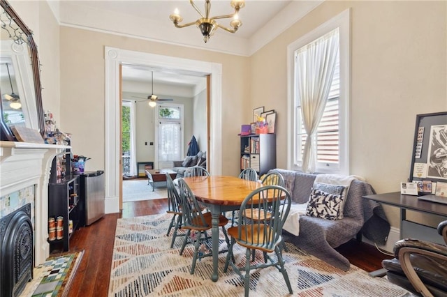 2329 Dauphine St, New Orleans, LA 70117 - dining room featuring wood finished floors, a chandelier, a fireplace, baseboards, and ornamental molding