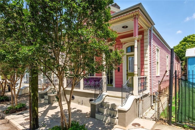 2329 Dauphine St, New Orleans, LA 70117 - view of front of property with fence, a gate, and a porch