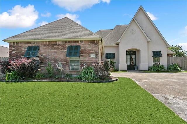 11446 Copperwood Dr, Denham Springs, LA 70726 - view of front of home featuring french doors, roof with shingles, brick siding, stucco siding, and driveway