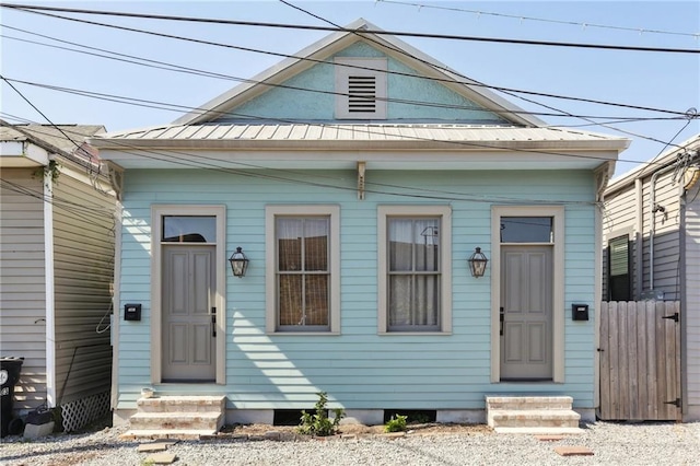 3979 S Front St, New Orleans, LA 70115 - view of front of home featuring entry steps, fence, and metal roof