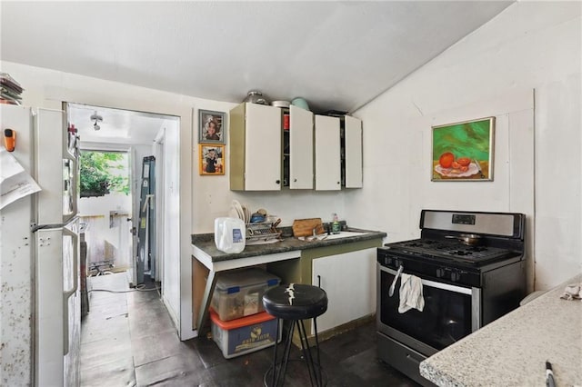 3979 S Front St, New Orleans, LA 70115 - kitchen featuring stainless steel range with gas stovetop, freestanding refrigerator, and a sink