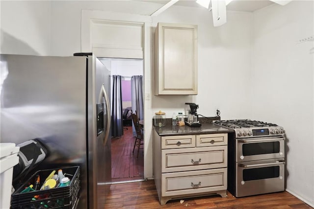 3979 S Front St, New Orleans, LA 70115 - kitchen with stainless steel appliances, cream cabinets, dark wood-type flooring, dark countertops, and a ceiling fan