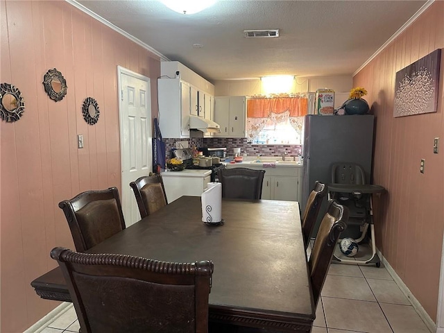 441315 Herrmann St, Metairie, LA 70006 - dining room with ornamental molding, light tile patterned floors, wood walls, and baseboards