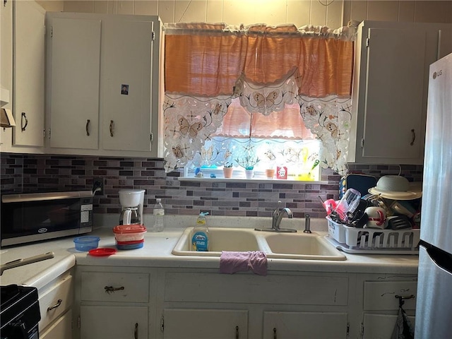 441315 Herrmann St, Metairie, LA 70006 - kitchen featuring stainless steel appliances, light countertops, decorative backsplash, a sink, and white cabinets