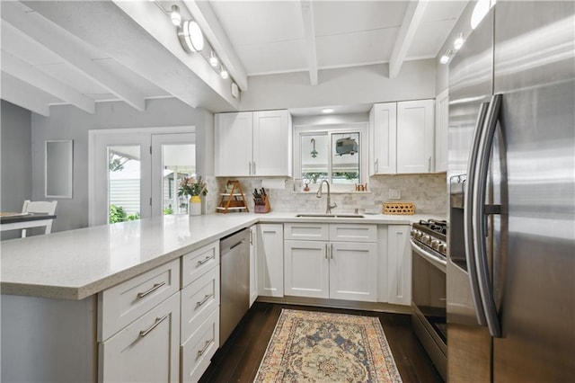 33 Caribou Ct, Metairie, LA 70003 - kitchen with appliances with stainless steel finishes, beamed ceiling, a sink, a peninsula, and plenty of natural light