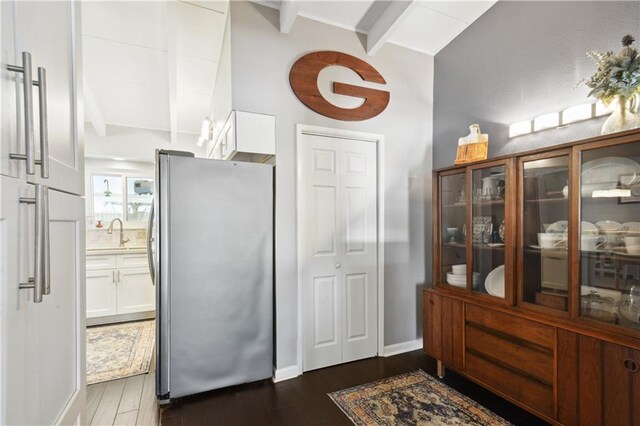 33 Caribou Ct, Metairie, LA 70003 - kitchen with freestanding refrigerator, dark wood-style floors, white cabinetry, and glass insert cabinets