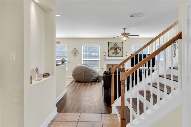 682 Amy Ct, Covington, LA 70433 - staircase featuring ceiling fan, baseboards, tile patterned flooring, and a fireplace