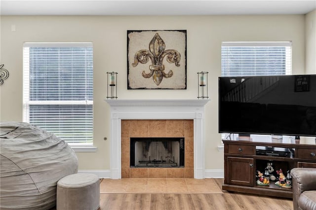 682 Amy Ct, Covington, LA 70433 - living area with a tiled fireplace, baseboards, and light wood finished floors