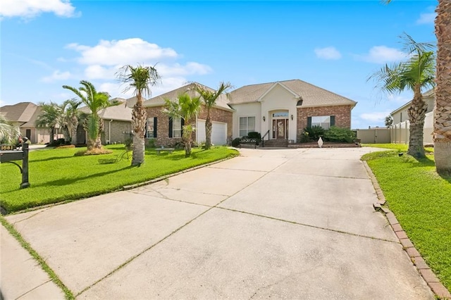 1681 Vela Cv, Slidell, LA 70458 - view of front of house with driveway, an attached garage, brick siding, and stucco siding