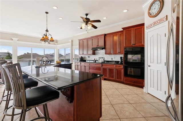 1681 Vela Cv, Slidell, LA 70458 - kitchen with dark countertops, ceiling fan, a sink, tasteful backsplash, and light tile patterned floors