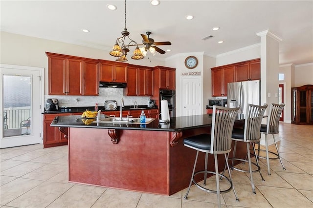 1681 Vela Cv, Slidell, LA 70458 - kitchen with dark countertops, a sink, under cabinet range hood, dark brown cabinets, and ornamental molding