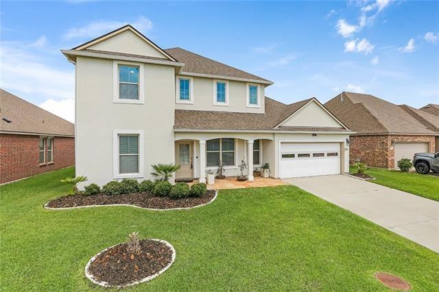693 Lakeshore Village Dr, Slidell, LA 70461 - traditional-style home with stucco siding, a garage, and a front yard