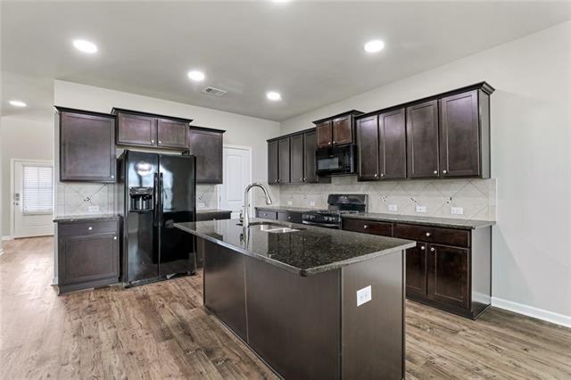 693 Lakeshore Village Dr, Slidell, LA 70461 - kitchen with black appliances, a sink, wood finished floors, dark brown cabinets, and baseboards