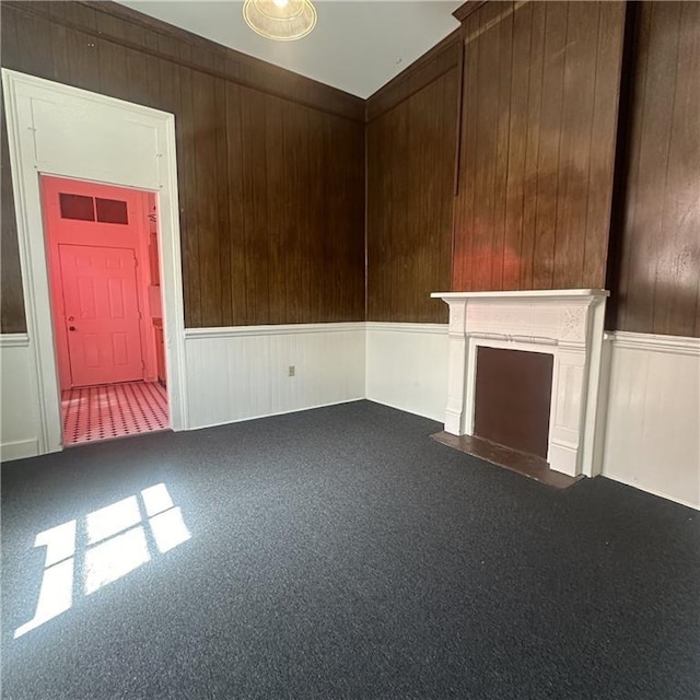 937-939 N Claiborne Ave, New Orleans, LA 70116 - unfurnished living room featuring carpet floors, a wainscoted wall, a fireplace with flush hearth, and wood walls