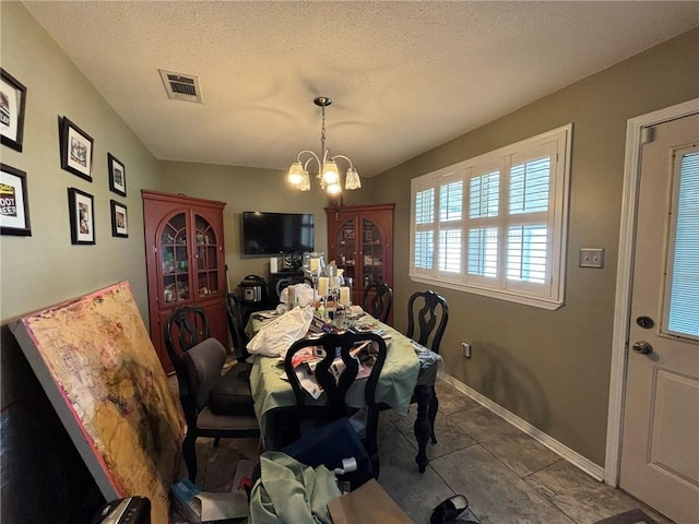 2132 Missille St, Harvey, LA 70058 - dining room with a chandelier, baseboards, dark tile patterned floors, and a textured ceiling