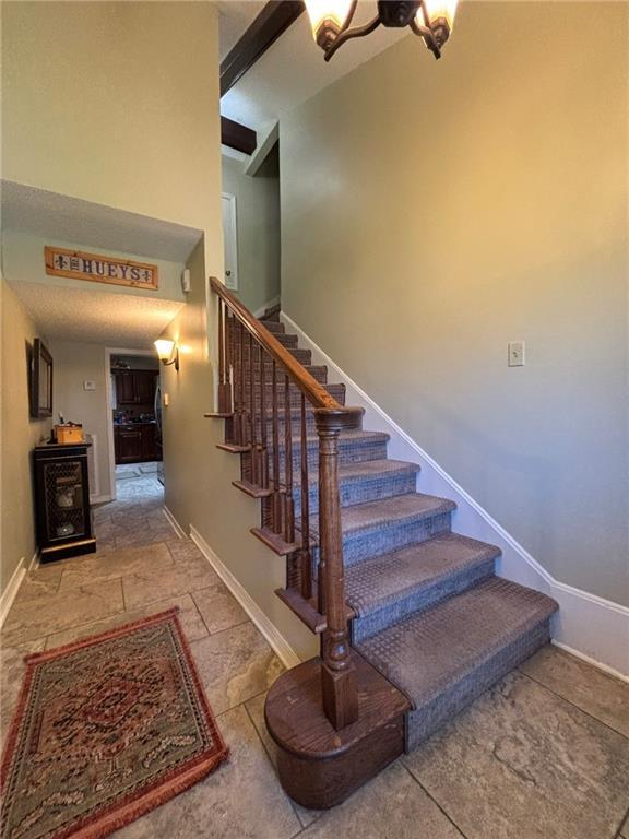 2132 Missille St, Harvey, LA 70058 - staircase featuring baseboards and stone finish floors