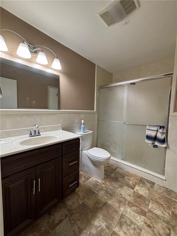 2132 Missille St, Harvey, LA 70058 - bathroom with a shower stall, vanity, toilet, tile walls, and lofted ceiling