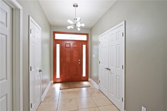 47013 Rivergate Dr, Robert, LA 70455 - entrance foyer featuring a chandelier, baseboards, and light tile patterned floors
