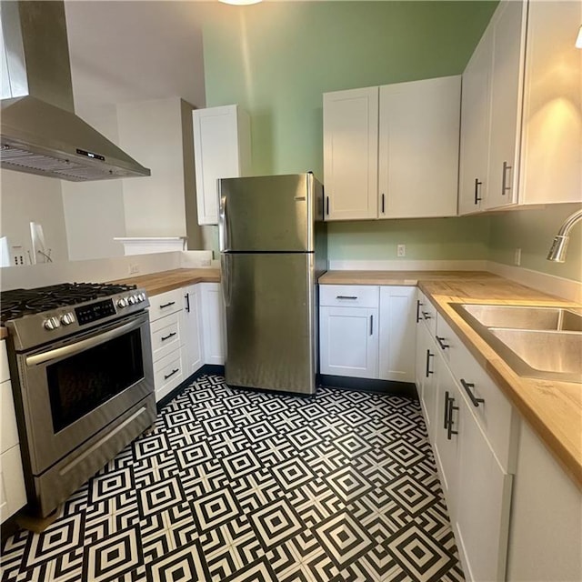 1915-1917 Bayou Rd, New Orleans, LA 70116 - kitchen with stainless steel appliances, wall chimney exhaust hood, a sink, white cabinets, and light flooring