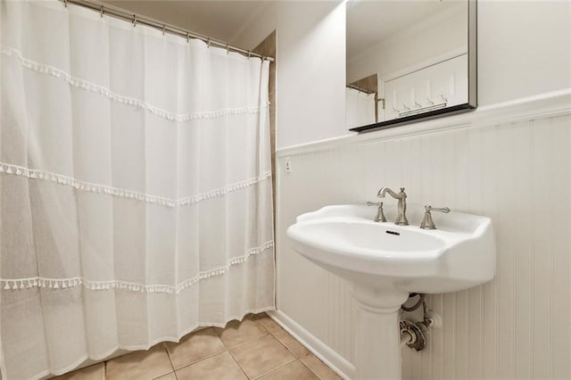 120 Pine Dr, Covington, LA 70433 - bathroom with tile patterned floors, a wainscoted wall, and curtained shower