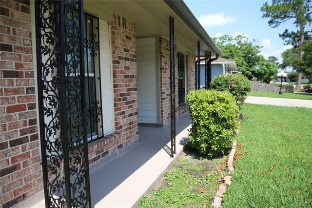 116 Southern Ct, Avondale, LA 70094 - view of exterior entry featuring brick siding and a yard