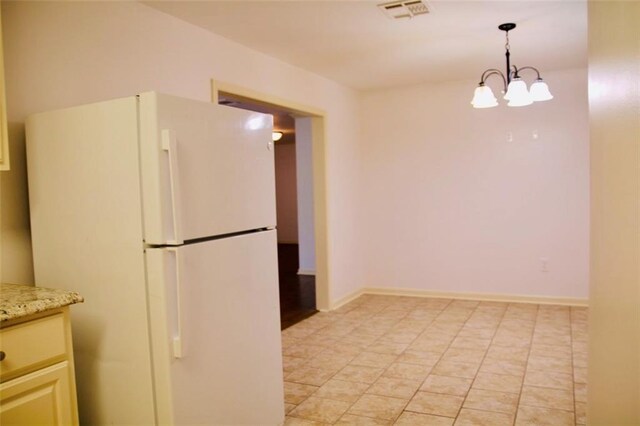 116 Southern Ct, Avondale, LA 70094 - kitchen with freestanding refrigerator, pendant lighting, a chandelier, and light stone countertops