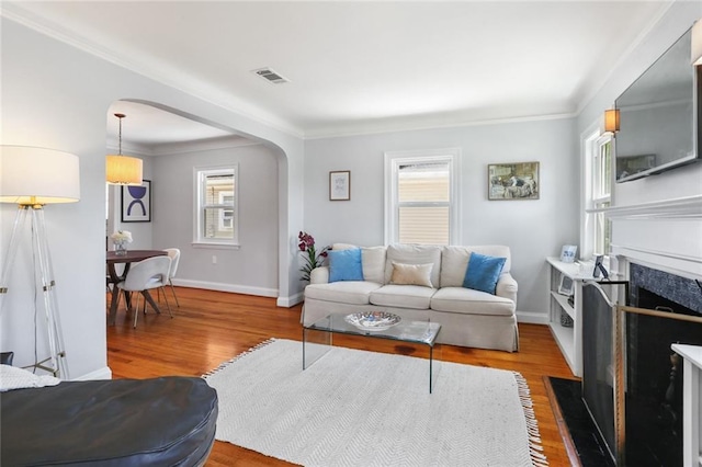 18 Davis Blvd, Jefferson, LA 70121 - living area with arched walkways, wood finished floors, crown molding, baseboards, and a fireplace with flush hearth