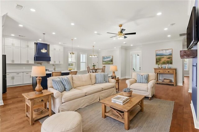 1109 David Dr, Metairie, LA 70003 - living room with ornamental molding, recessed lighting, a ceiling fan, light wood finished floors, and baseboards