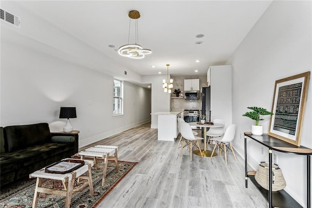 310507 Toulouse St, New Orleans, LA 70119 - living area with a chandelier, light wood-style flooring, and recessed lighting