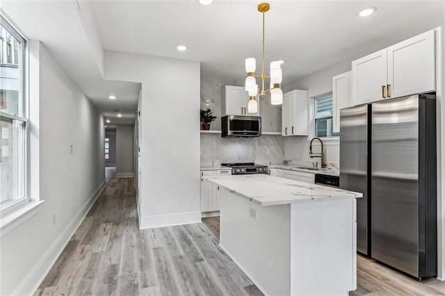 310507 Toulouse St, New Orleans, LA 70119 - kitchen featuring appliances with stainless steel finishes, decorative backsplash, white cabinetry, a kitchen island, and recessed lighting