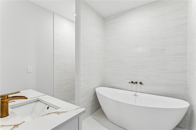 310507 Toulouse St, New Orleans, LA 70119 - full bathroom featuring a soaking tub, marble finish flooring, vanity, and tile walls