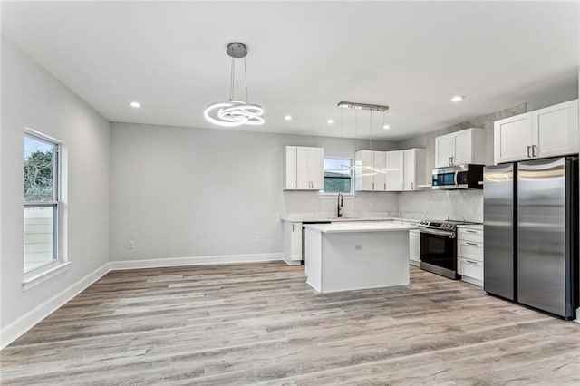 310507 Toulouse St, New Orleans, LA 70119 - kitchen with appliances with stainless steel finishes, white cabinetry, light countertops, recessed lighting, and light wood finished floors