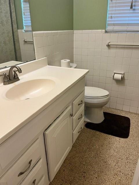 1329 Sigur Ave, Metairie, LA 70005 - bathroom featuring tile walls, toilet, vanity, and a wainscoted wall