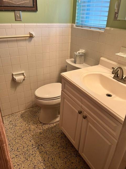 1329 Sigur Ave, Metairie, LA 70005 - half bathroom with tile walls, toilet, a wainscoted wall, and vanity