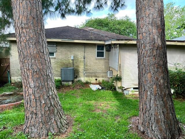 1329 Sigur Ave, Metairie, LA 70005 - rear view of property with a shingled roof, brick siding, crawl space, a yard, and cooling unit