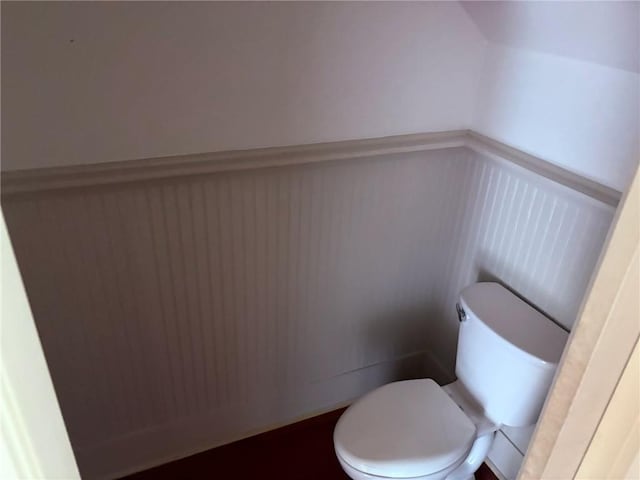 913 N Robertson St, New Orleans, LA 70116 - bathroom with a decorative wall, wainscoting, and toilet