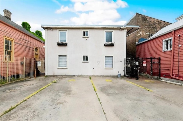 1031 Henriette Delille St Unit 7, New Orleans, LA 70116 - back of property with stucco siding, uncovered parking, and a gate