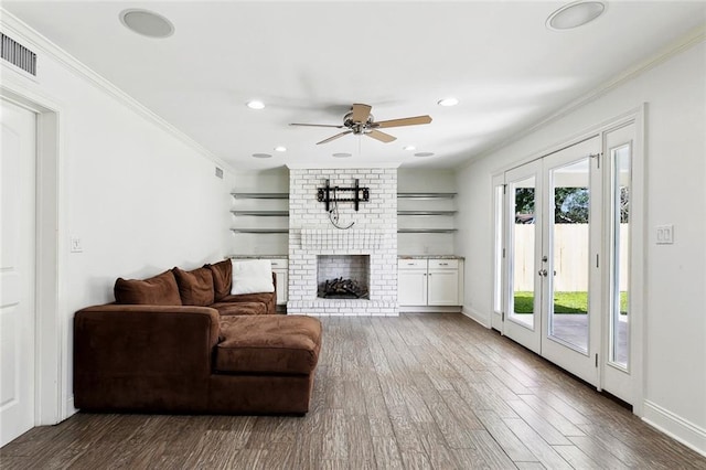 9108 Ormond Pl, River Ridge, LA 70123 - living room with crown molding, wood finished floors, french doors, ceiling fan, and a fireplace