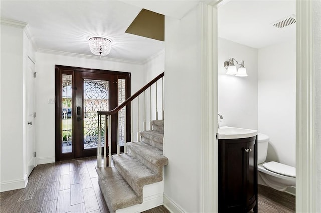 9108 Ormond Pl, River Ridge, LA 70123 - foyer entrance with baseboards, stairs, wood finished floors, crown molding, and a chandelier