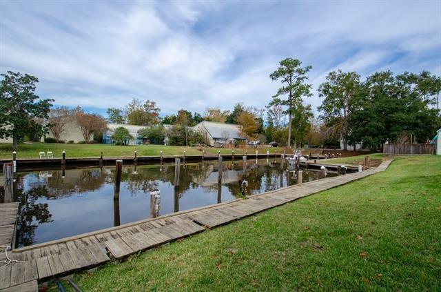 350 Atalin St Unit 11A, Mandeville, LA 70448 - dock with a lawn and a water view