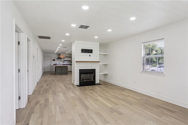 1401 Claiborne Dr, Jefferson, LA 70121 - unfurnished living room featuring light wood-style flooring, baseboards, recessed lighting, and a large fireplace