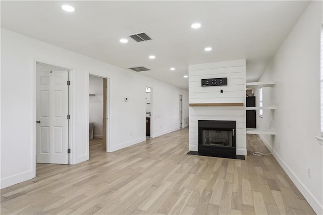 1401 Claiborne Dr, Jefferson, LA 70121 - unfurnished living room featuring light wood-style flooring, recessed lighting, a large fireplace, and baseboards