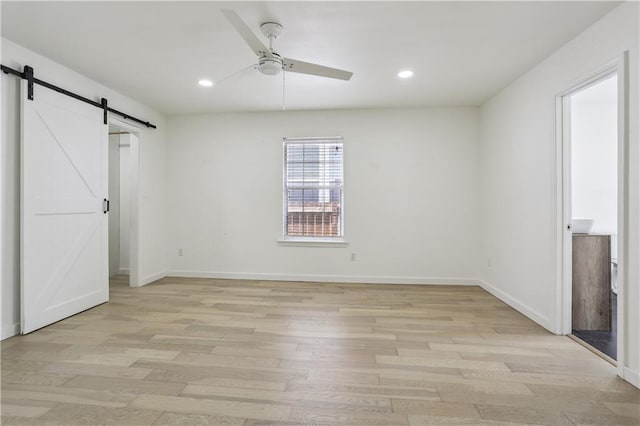 1401 Claiborne Dr, Jefferson, LA 70121 - unfurnished bedroom featuring a barn door, light wood-type flooring, recessed lighting, and baseboards