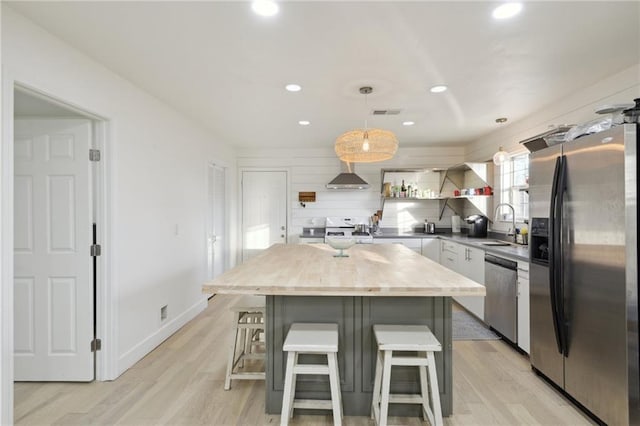 1401 Claiborne Dr, Jefferson, LA 70121 - kitchen featuring stainless steel appliances, a kitchen breakfast bar, wood counters, recessed lighting, and a center island
