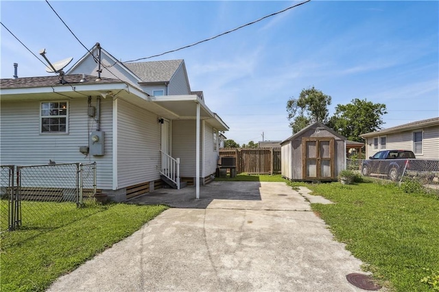 1401 Claiborne Dr, Jefferson, LA 70121 - view of home's exterior featuring a storage unit, an outdoor structure, concrete driveway, and entry steps