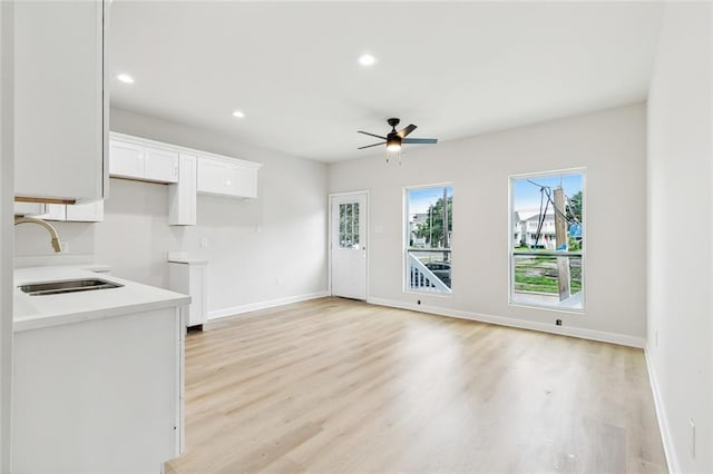 340606 Jackson Ave, New Orleans, LA 70125 - kitchen with a sink, a ceiling fan, white cabinets, light wood finished floors, and recessed lighting
