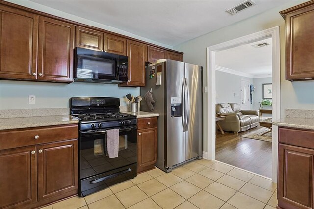 309 Wallace Dr, New Orleans, LA 70122 - kitchen with black appliances, crown molding, light tile patterned floors, and open floor plan